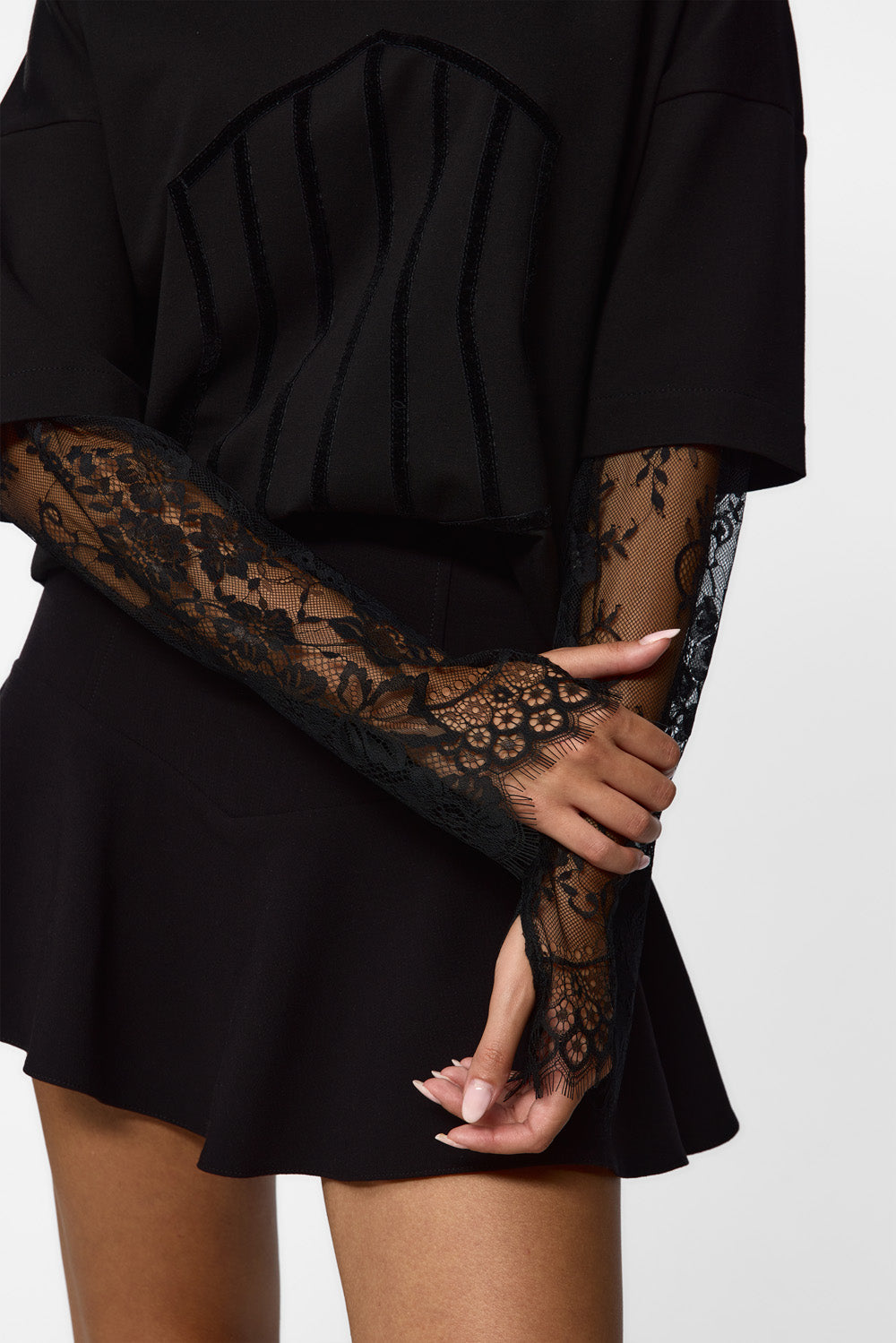 Person wearing a black outfit with lace sleeves on a white background. Venice T-shirt for women from Hamza