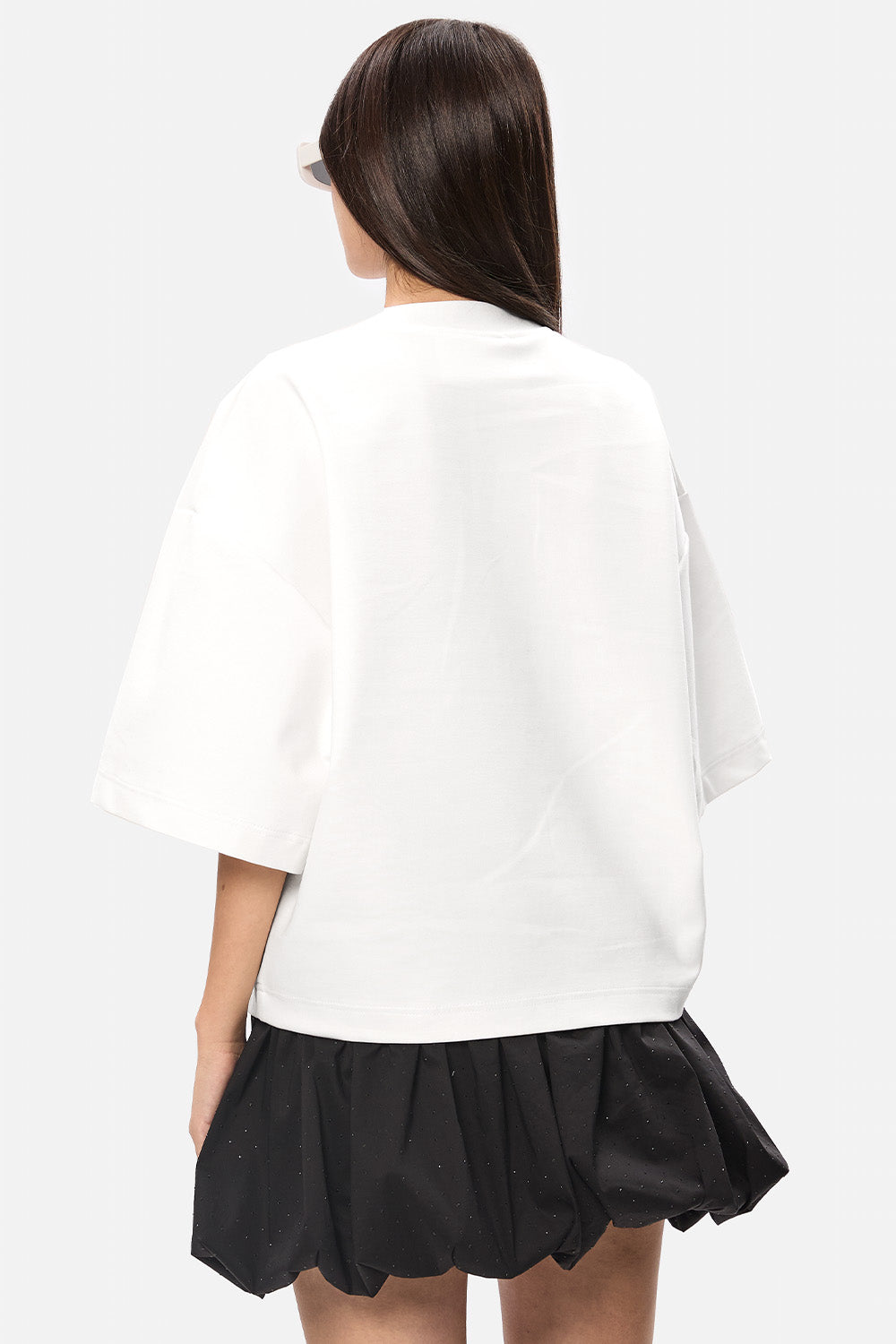 Model poartă tricou femei off-white oversized din vâscoză cu mâneci clopot, vedere din spate.